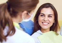 A young woman listening to her dentist discuss her treatment options