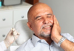 Older man holding jaw in pain