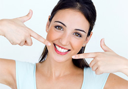 Woman pointing to her flawless smile