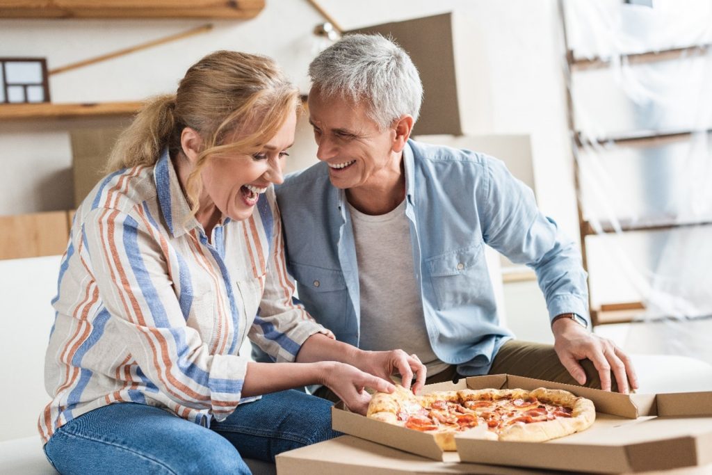 Couple with dentures about to enjoy a pizza.